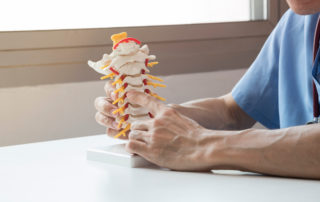 a doctor explaining neck pain on a model